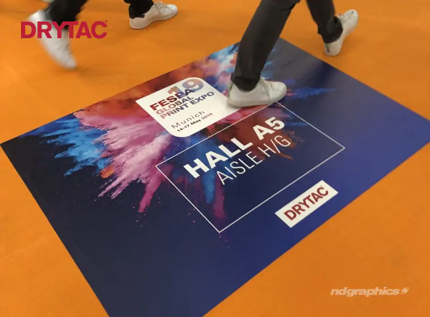 People walking on a colourful FESPA carpet graphic