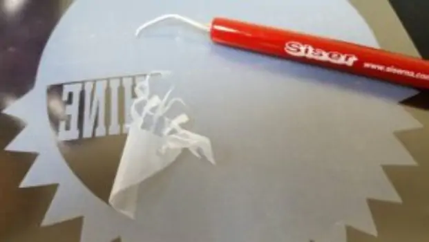 White peel-off layer of adhesive, with red Siser pen resting on top