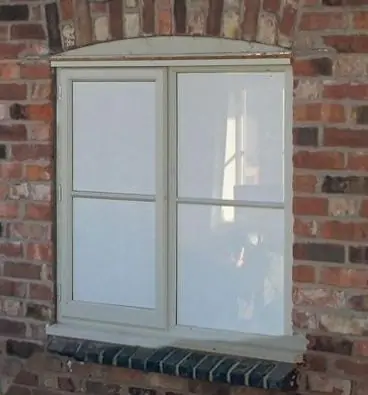 A tinted window on a brick wall