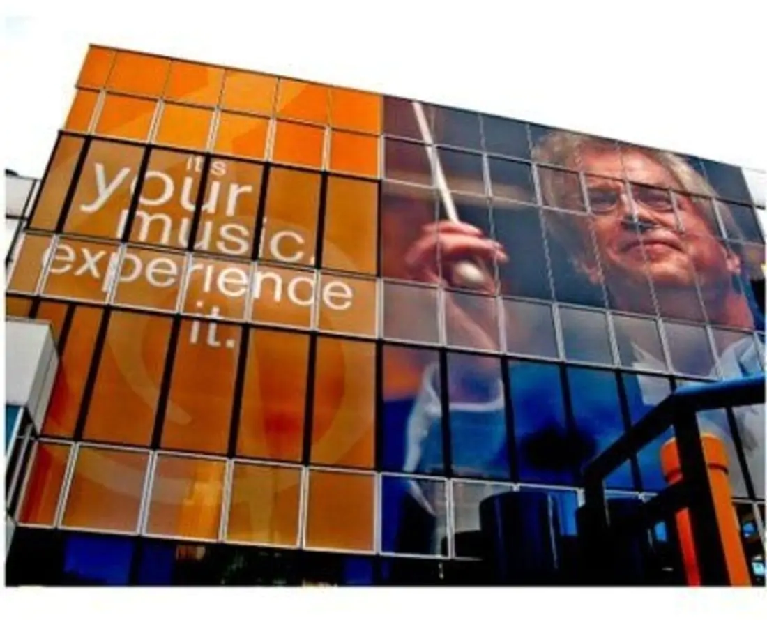 Building covered in 60/40 Perforated Window film graphic of a man alongside an orange background