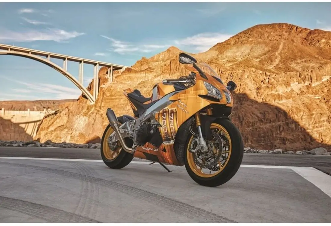 Orange motorcycle with 780mC-10R Conformable Reflective in front of a rock and bridge 