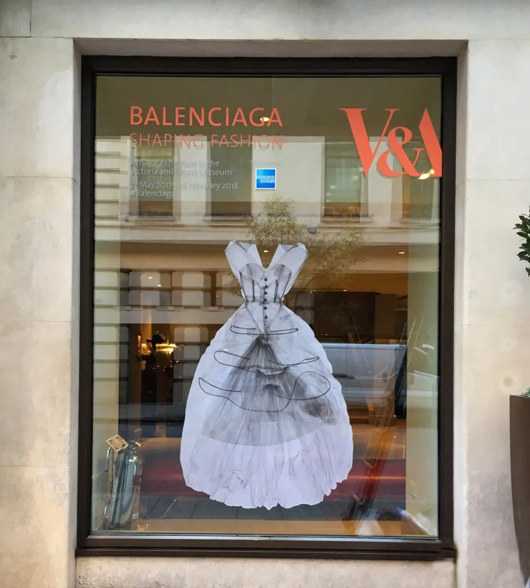 Glass Window with Orange Balenciaga sign on it and a picture of a white dress 