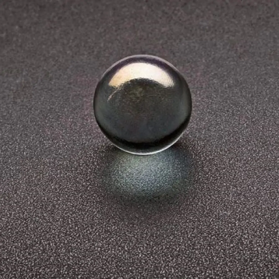 A black circular ball with a glare 