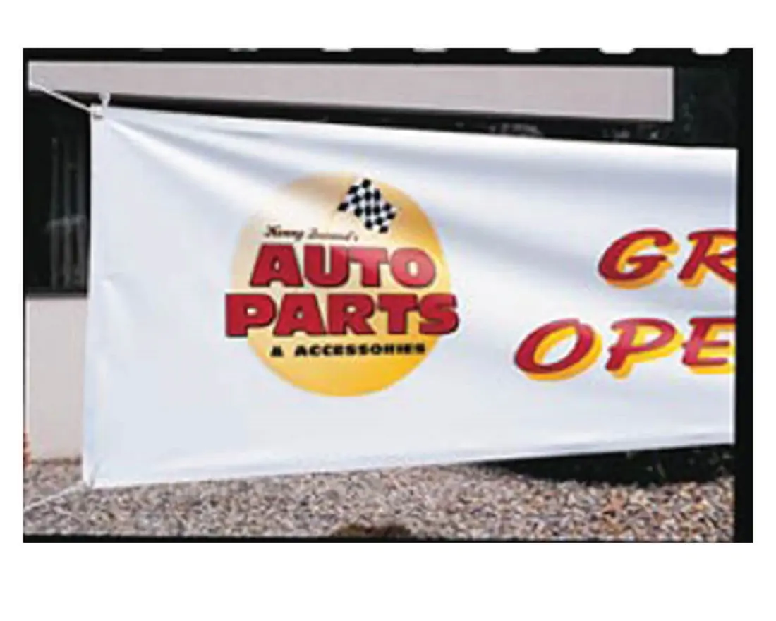A big white sign being held up, and has red and yellow words saying Auto Parts 
